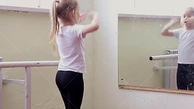The young girl dances in a ballet tutu in the hall