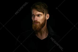 Closeup portrait of bearded handsome man in a pensive mood looking away
