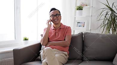 Happy man calling on smartphone at home