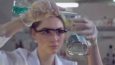 Woman adding liquid to glass bulb.