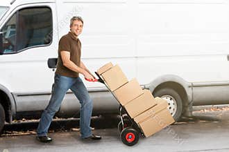 Delivery Man Pushing Parcels On Handtruck