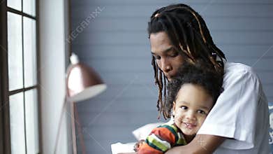 African american father embracing his little son