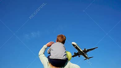 Happy people meet plane, mother shows child on plane, Happy family on background of flying airplane, airbus sits down