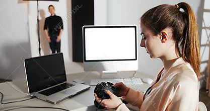 Female photographer reviewing captured photos in his digital camera at studio