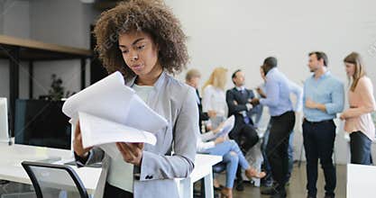 Happy smiling businesswoman reading successful report documents over meeting of business people team in modern creative