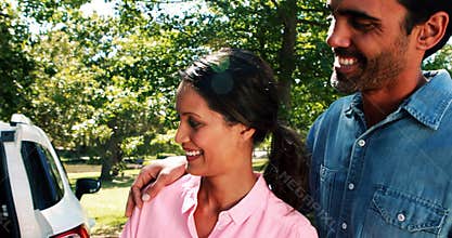 Family on a picnic standing next to their car