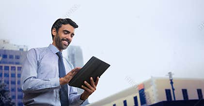 Happy business man using a tablet against city background