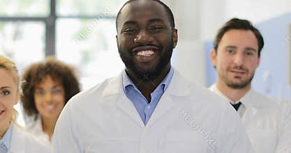 African American Scientist Man Happy Smiling Over Mix Race Team Of Researchers In Modern Laboratory