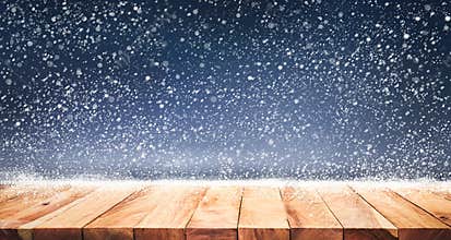 Wood table top with snowfall of winter season background.christmas