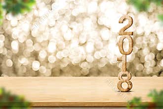 Happy new year 2018 on wood table and blur Christmas tree foreground at blur sparkling gold bokeh light wall,panoramic banner for