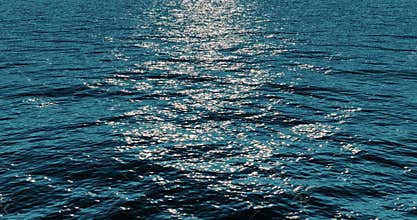 Blue sea ocean waves water calm movement background in sunny day with sun light on surface, nature and peace