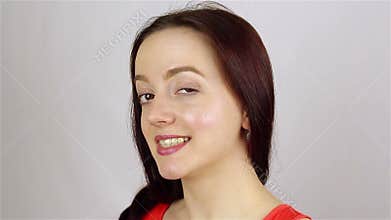 Young beautiful woman looks at the camera and winks