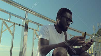 Millennial guy shopping online with smartphone outdoors
