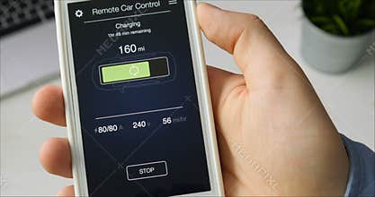 Man checks charge level of his car. Charging in progress Car remote control using smartphone application fictional