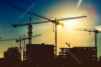 tower cranes on industrial construction site. New district development and skyscraper building