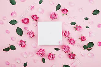 White frame blank, pink rose flowers and petals for spa or wedding mockup on pastel background top view. Beautiful floral pattern.