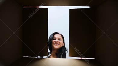 Happy woman opening cardboard parcel box