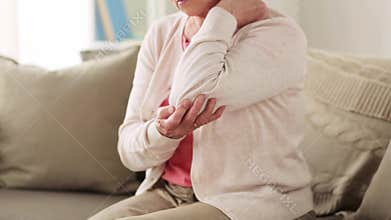 Senior woman suffering from pain in hand at home