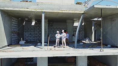 Aerial Shot Of Builders Team On Construction Site Discussing Plan Of Project With Architect And Contractor Using