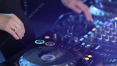 Hands of woman Dj play music on mixing console, closeups