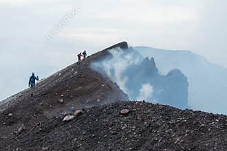 Hikers Reaching the Top of Etna Volcano amidst Steam Clouds