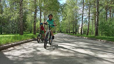 Three brothers riding bikes in sunny day.