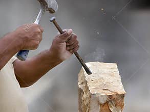 Stone mason shaping block of stone
