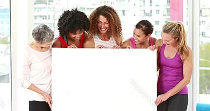 Smiling athletic women pointing a copy space
