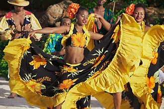 People wearing colorful dresses perform traditional creole Sega dance at sunset in Ville Valio, Mauritius.