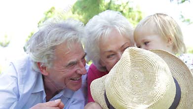 Grandparents And Granddaughter Having Fun In Park Together