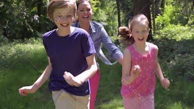 Mother Chasing Children Along Woodland Path