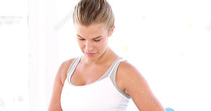 Smiling athletic woman carrying yoga mat