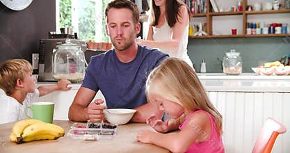 Family Eating Breakfast In Kitchen Together