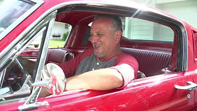Retired Senior Man Starting Engine Of Restored Classic Car