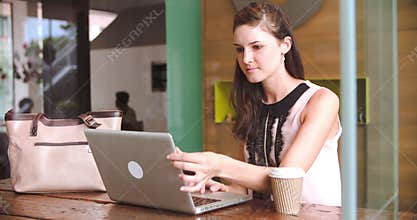 Young Businesswoman Working On Laptop In Coffee Shop