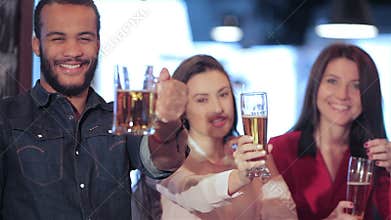 Young company lifts up a glass of beer