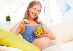 Happy pregnant woman eats healthy food vegetable salad
