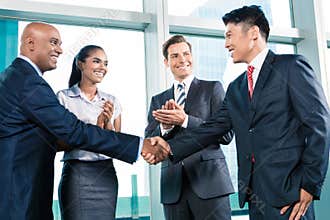 Business handshake in lofty office with city view