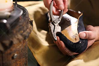 Shoemaker sews shoes