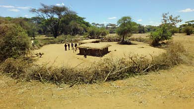 Aerial of a tribal hut in African rift valley with thorny fence in vast savannah