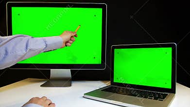 Man Working on the Laptop and Display with a Green Screen