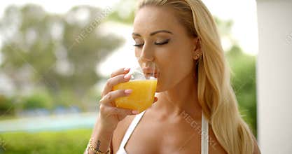 Woman Drinking Glass of Orange Juice Outdoors