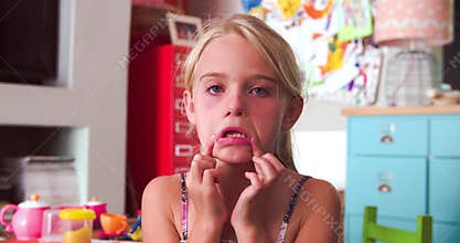 Girl In Bedroom Pulling Funny Faces At Camera