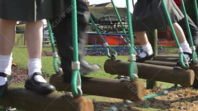 Elementary School Pupils Balancing On Climbing Equipment