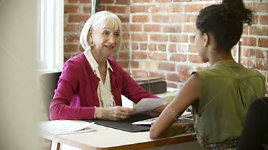 Older Businesswoman Interviewing Younger Woman In Office