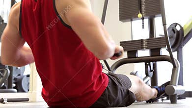 Young Man Using Weight Lifting Machine In Gym