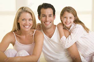 Family sitting in bed smiling