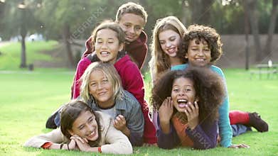 Group Of Children Lying On Grass Together In Park