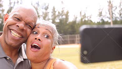 Senior Couple Taking Selfie In Park