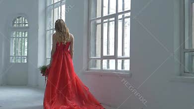 Pretty girl in gorgeous red dress walking past the